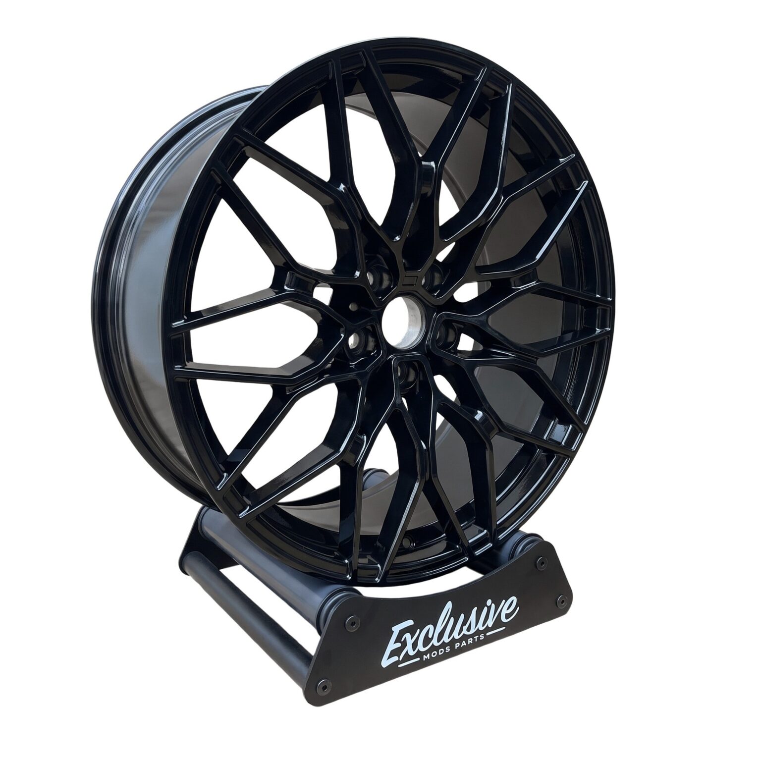 1000M style alloy wheel in gloss black on the Exclusive Mods Parts display stand, three-quarter view