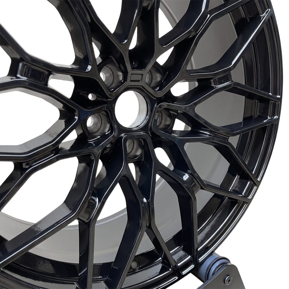 Close-up of the gloss black 1000M style alloy wheel spokes and centre bore