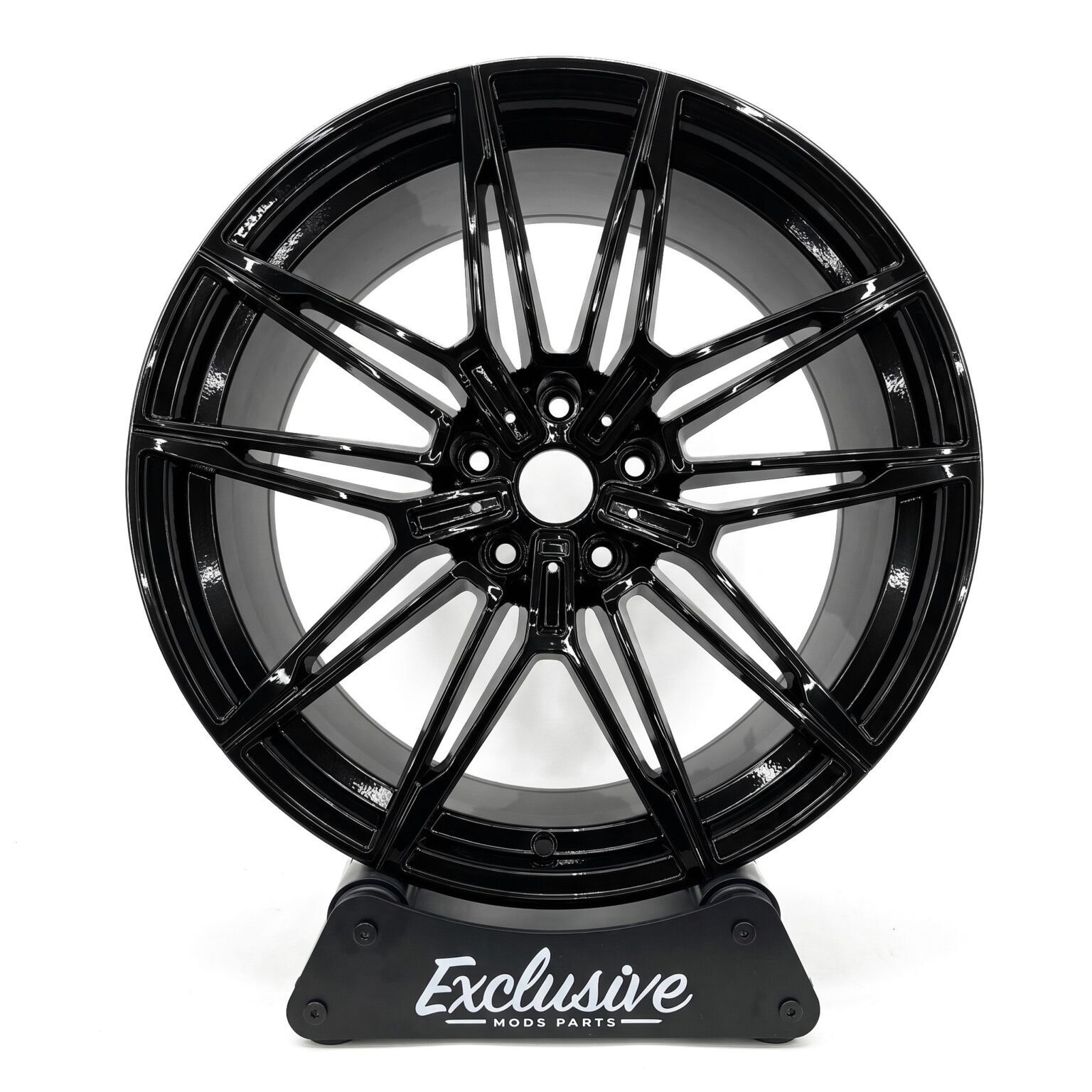 930M style alloy wheel in gloss black on the Exclusive Mods Parts display stand, front view